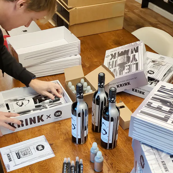 Simon from n-fuze packing the KRINK x Barossa Ink influencer boxes with bottles of wine, silver ink bottles, KRINK marker pens, leaflets, and serial numbered cards.